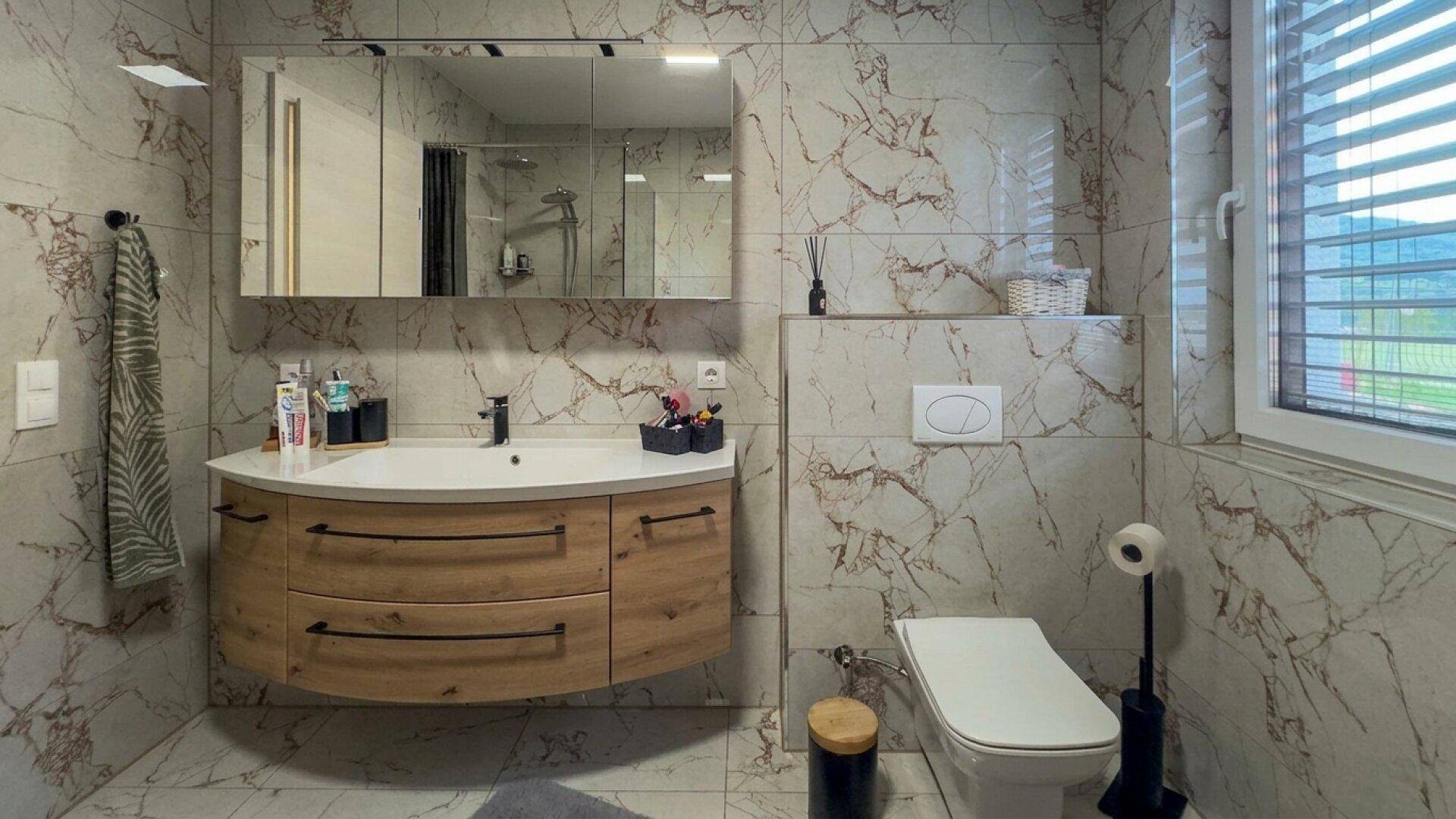 Modernes Badezimmer mit schwebendem Holzwaschtisch, Spiegelschrank und Wand-WC.