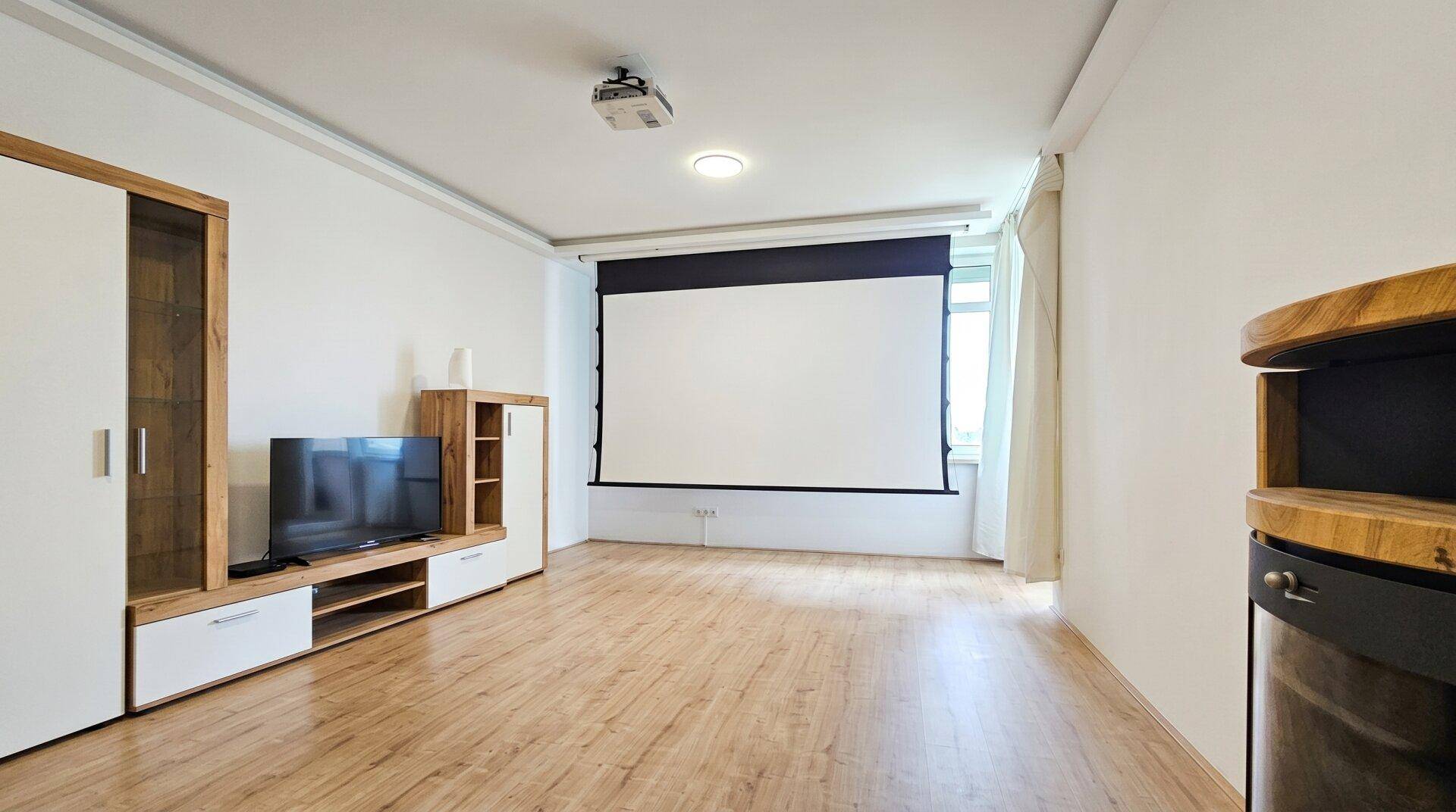 Wohnzimmer mit Holzboden, Projektor und TV-Möbeln, ideal für Unterhaltung.
