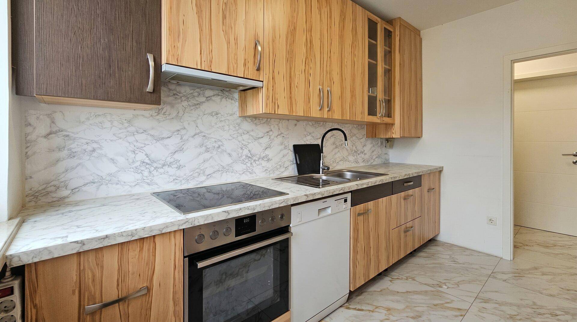 Moderne Küche mit Holzfronten, Marmor-Arbeitsplatte und integrierten Geräten.