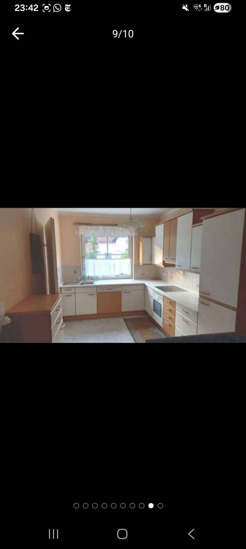 Funktionale Küche mit hellen Schränken, Fenster und ausreichend Arbeitsfläche.