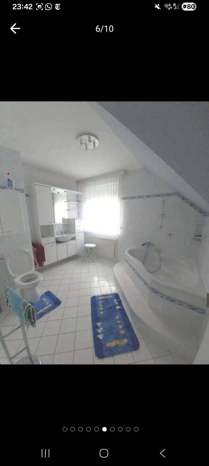 Helles Badezimmer mit Badewanne, WC, Fenster und Dachschräge.