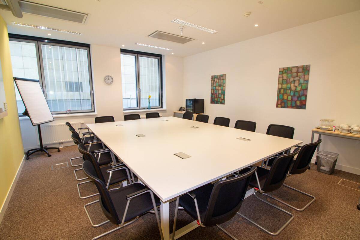 Geräumiger Konferenzraum mit einem großen Besprechungstisch und vielen Stühlen, ideal für größere Meetings.