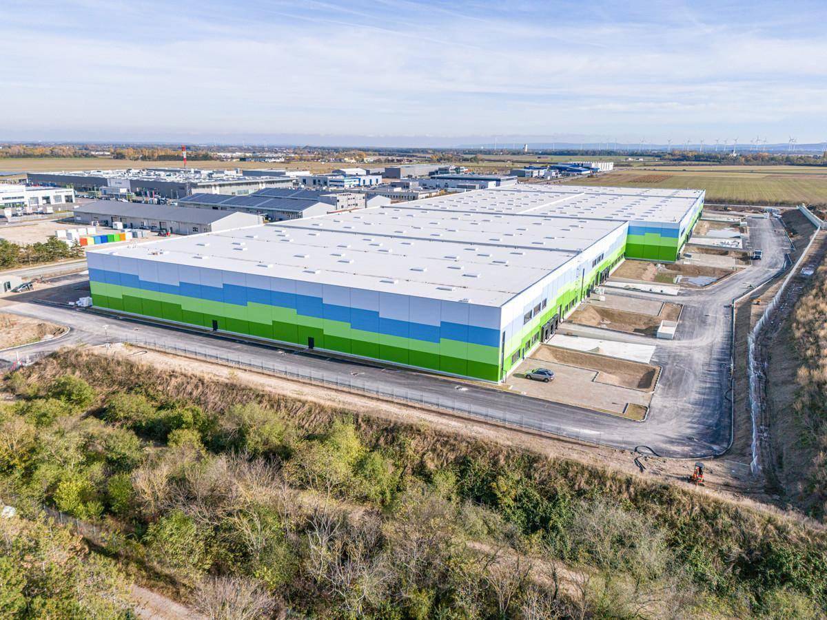 Weitläufige Luftansicht des Logistikzentrums, umgeben von weiteren Industriegebäuden und Feldern.