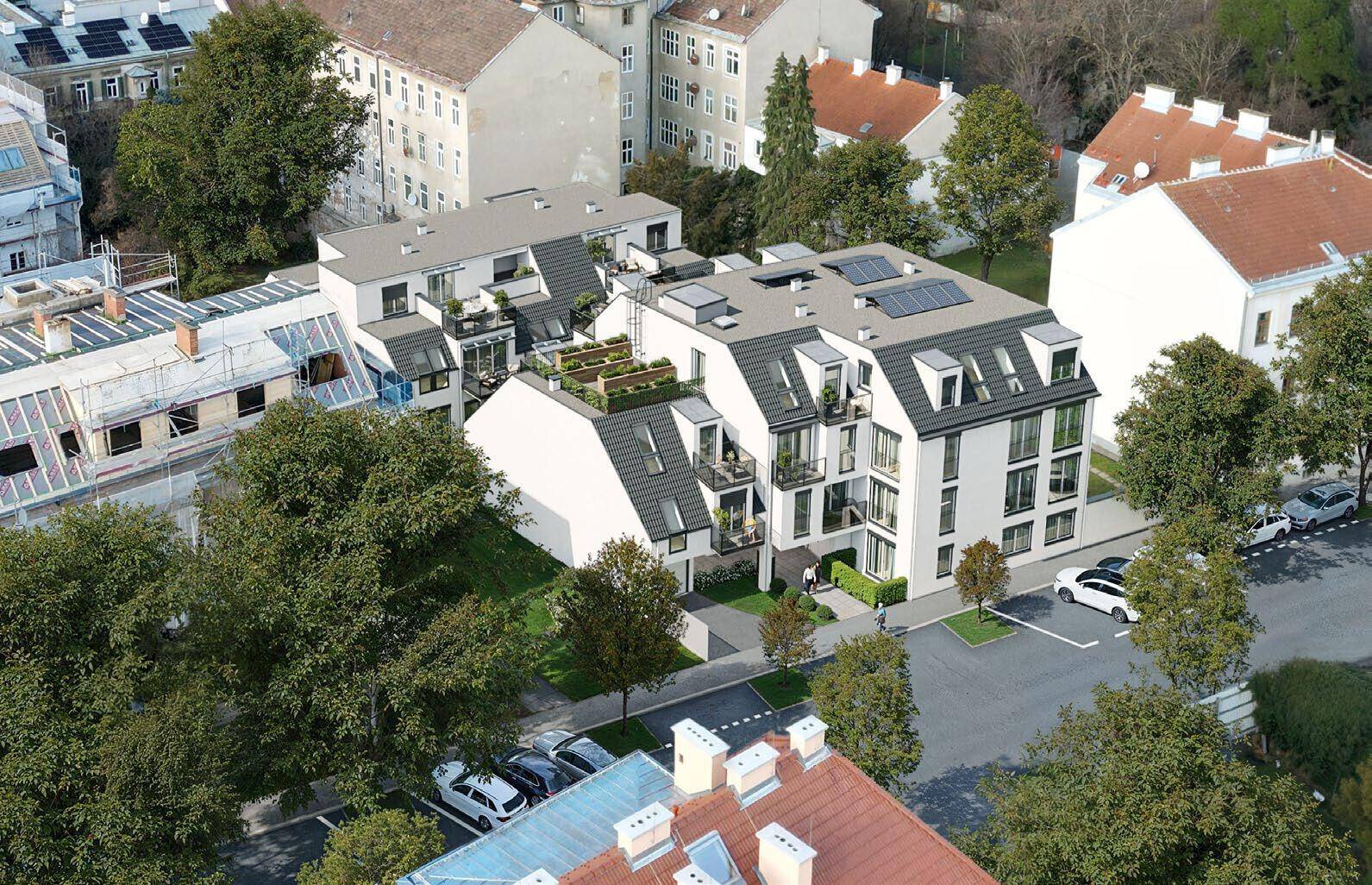 Nahaufnahme aus der Vogelperspektive eines modernen Wohnkomplexes mit Dachterrassen, Balkonen und Solaranlagen in städtischer Lage.