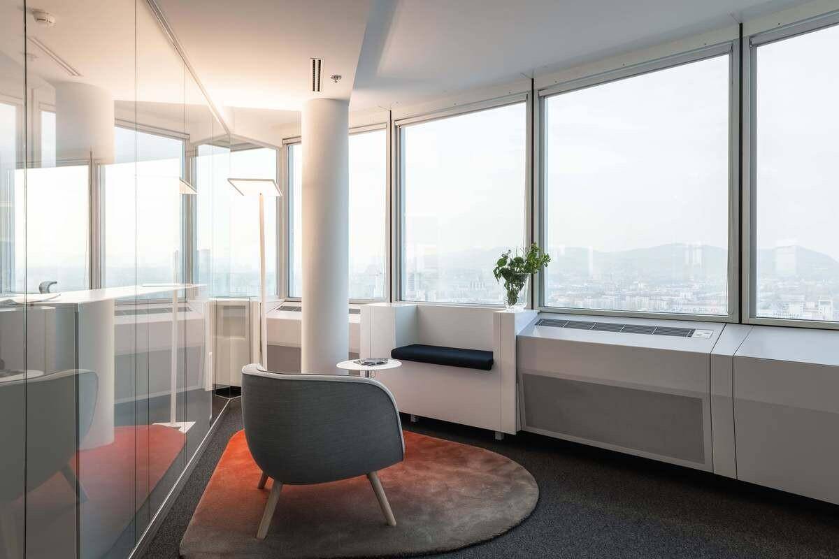 Heller Wartebereich mit bequemen Sitzgelegenheiten, Teppichboden und weitem Blick über die Stadt.