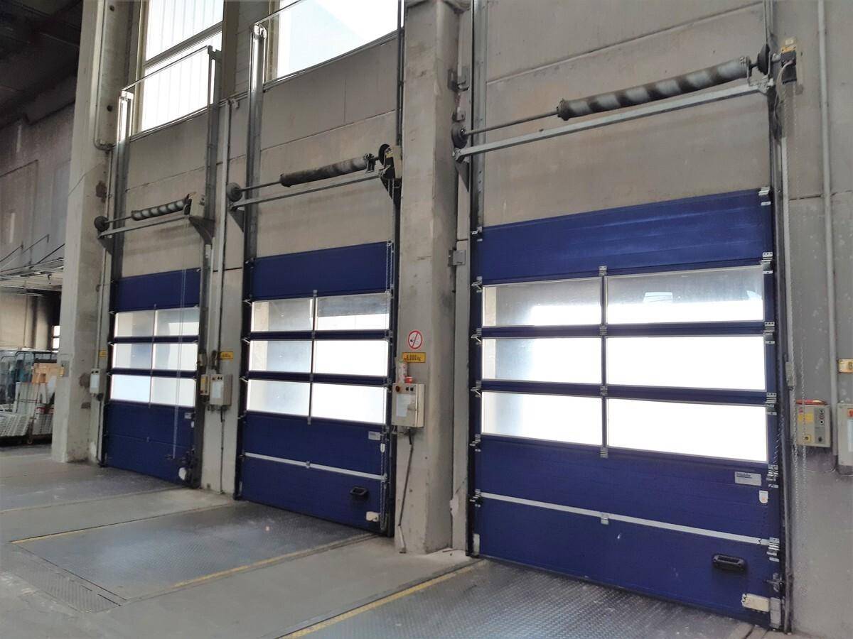 Blaue Rolltore der Laderampen im Inneren der Lagerhalle, bereit für den Warenverkehr.