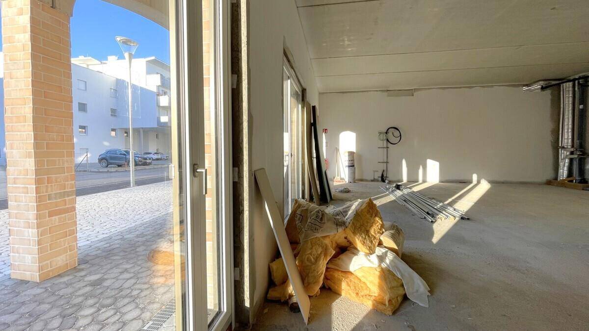 Blick aus dem Rohbau auf die charakteristische Bogenarchitektur des Gebäudes und den Außenbereich.