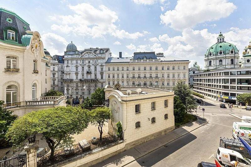 Panoramablick auf historische Gebäude und eine belebte Kreuzung in der Stadt unter blauem Himmel.