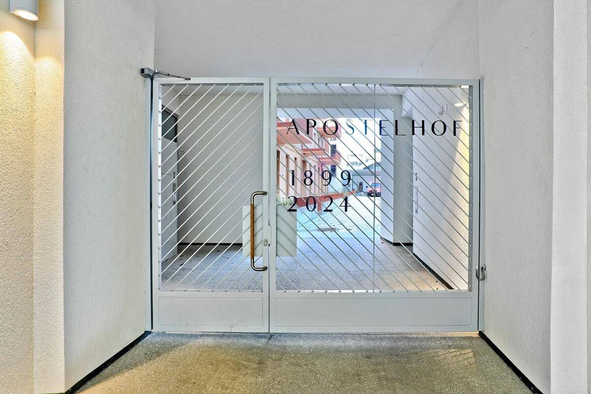 Heller Eingangsbereich mit einer modernen Glastür, die den Blick in den Innenhof freigibt.