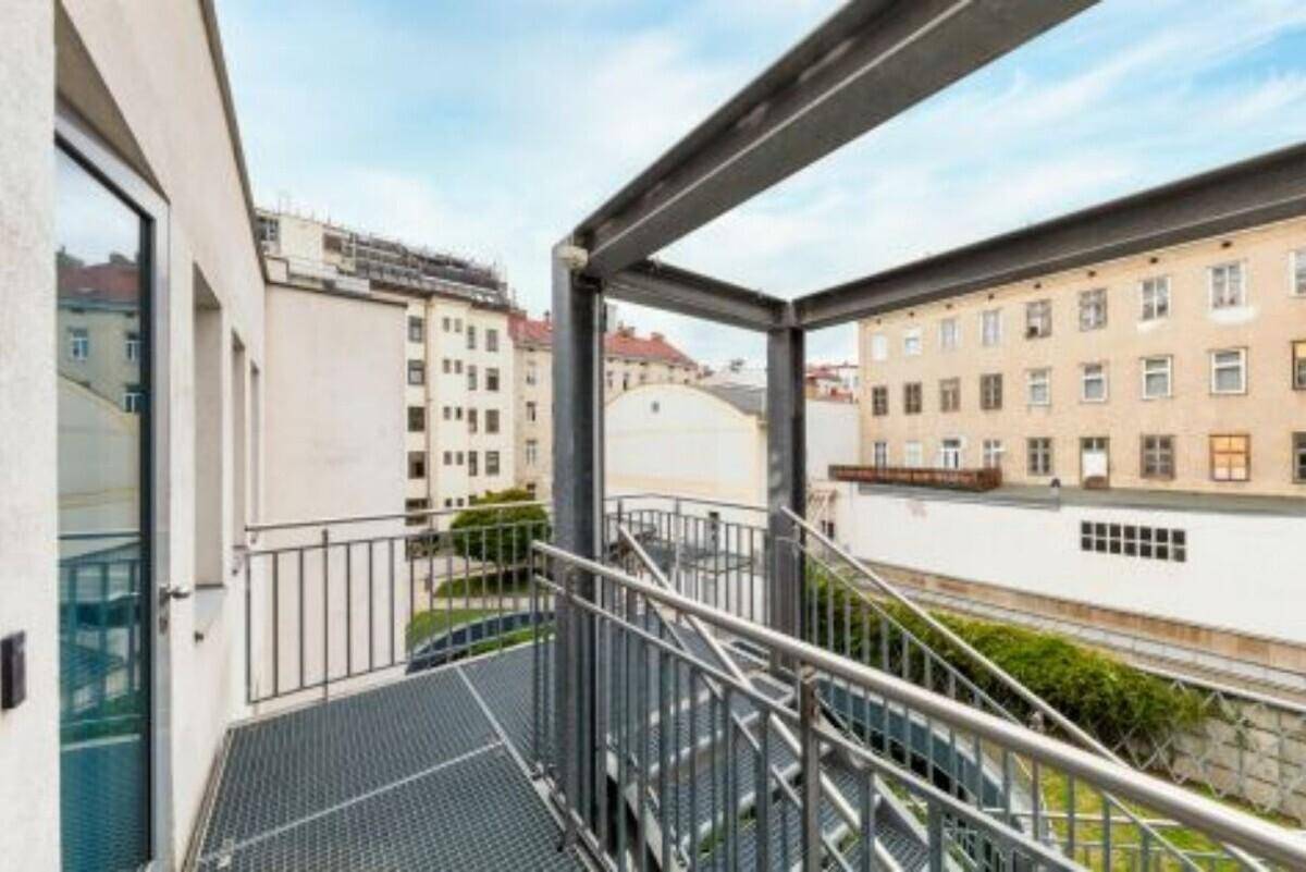 Metallbalkon mit Treppe und Blick auf umliegende Gebäude.
