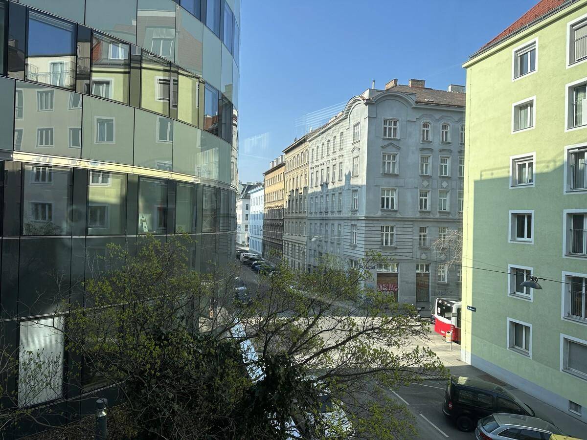 Blick aus dem Fenster auf eine Stadtstraße mit einer Mischung aus modernen und historischen Gebäuden.