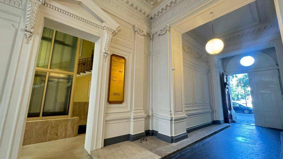 Eindrucksvolles Foyer mit hohen Decken, Stuckverzierungen und einem barrierefreien Zugang zur Treppe.