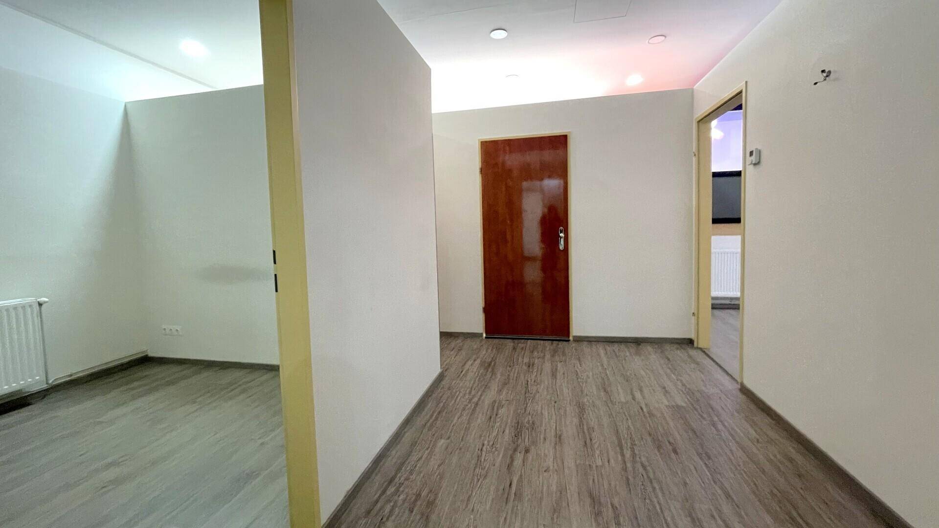 Heller Flur mit Holzboden und mehreren Türen, der zu verschiedenen Büroräumen führt.