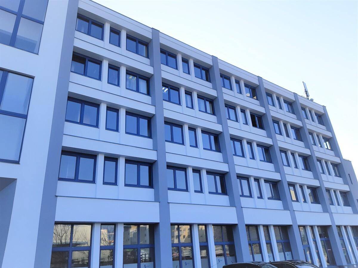 Ansicht der modernen Bürogebäude-Fassade mit vielen Fenstern und klaren Linien.