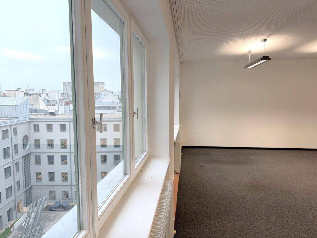 Büroraum mit weitem Blick über die Dächer der Stadt durch große, helle Fenster.