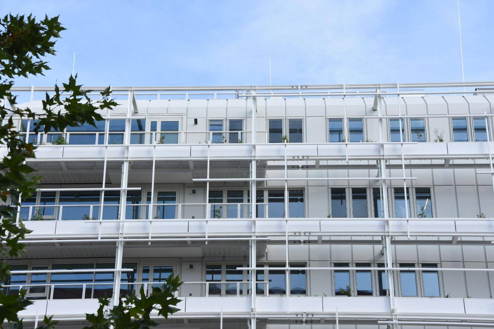 Nahaufnahme der Gebäudefassade mit vielen Fenstern und den charakteristischen Balkonen.