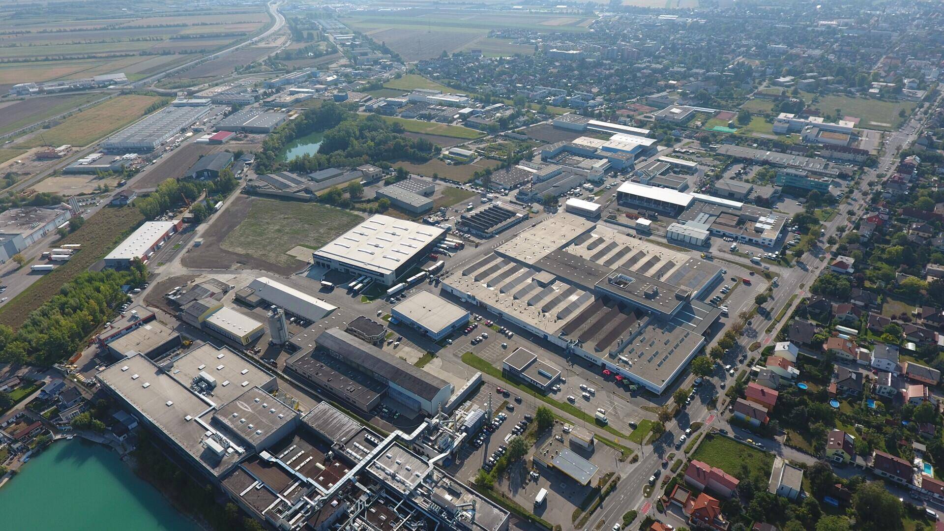 Luftaufnahme eines weitläufigen Industrieparks mit zahlreichen Lagerhallen und Gewerbegebäuden.
