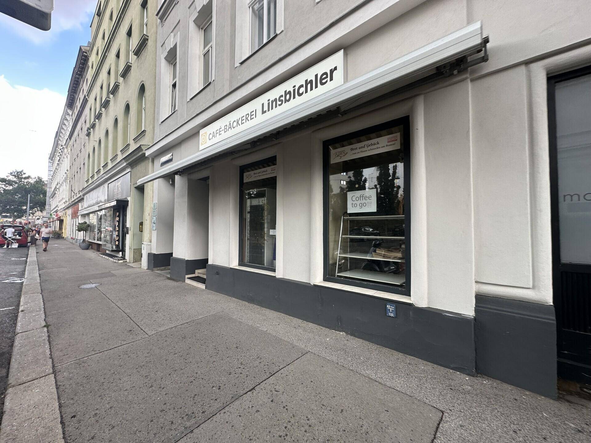 Straßenansicht einer Geschäftszeile mit einer Bäckerei und angrenzenden Gebäuden.