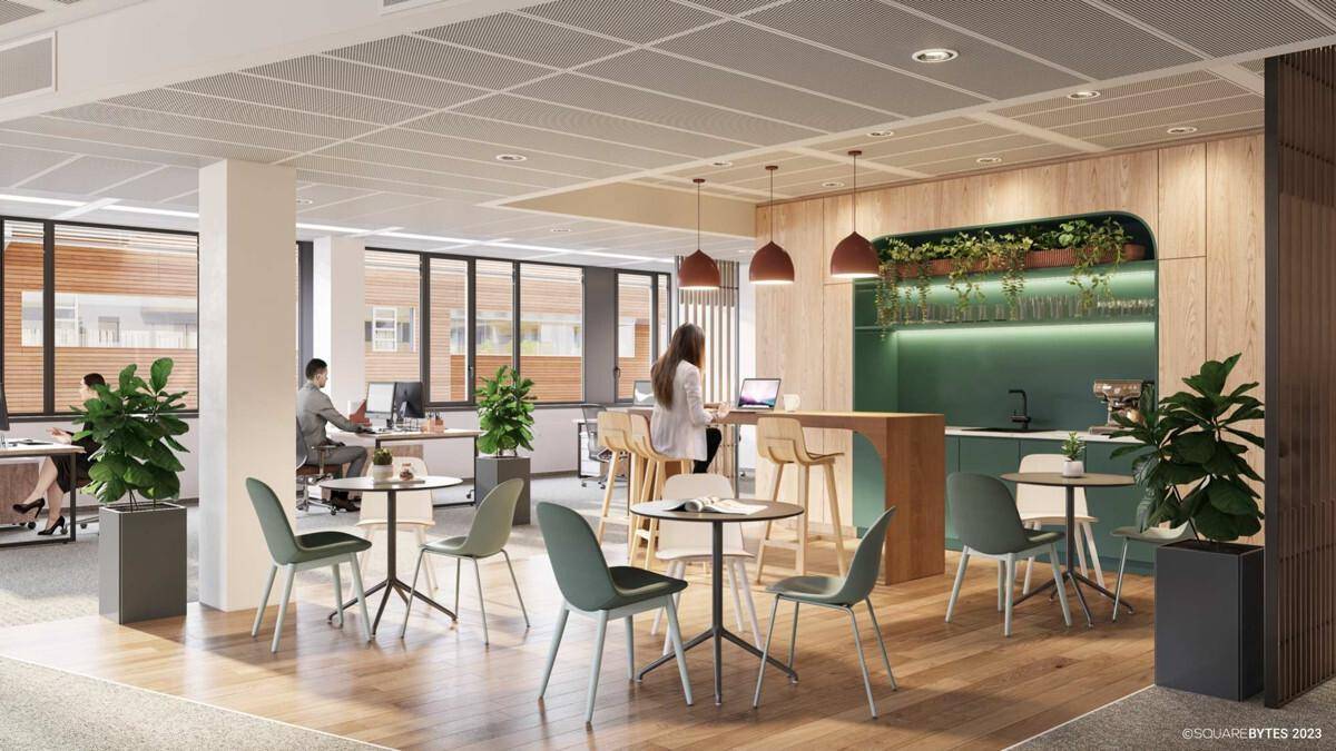 Moderne Büroküche mit Holzboden, Bartheke und integrierter Kaffeemaschine für Mitarbeiterpausen.