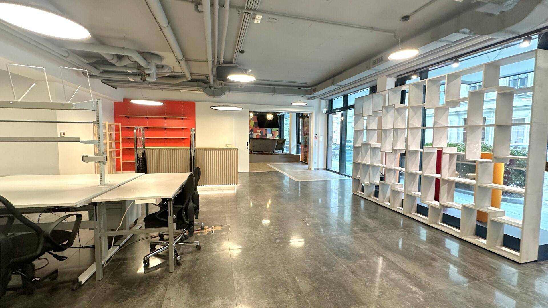 Geräumiger, moderner Bürobereich mit Betonboden, freiliegenden Rohren und großen Fenstern für viel Tageslicht.