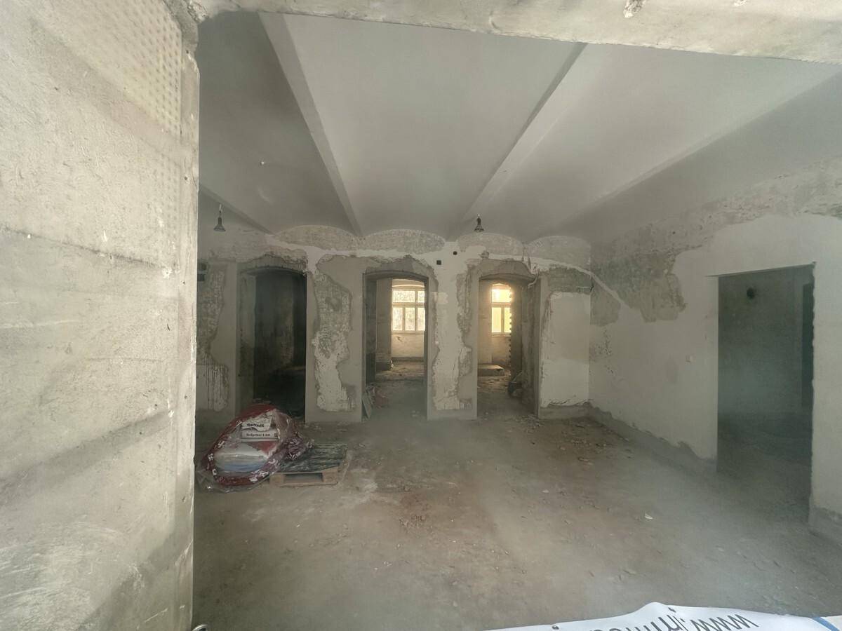 Ein unfertiger Innenraum im Rohbauzustand mit sichtbaren Wänden und Decken, bereit für den Ausbau.