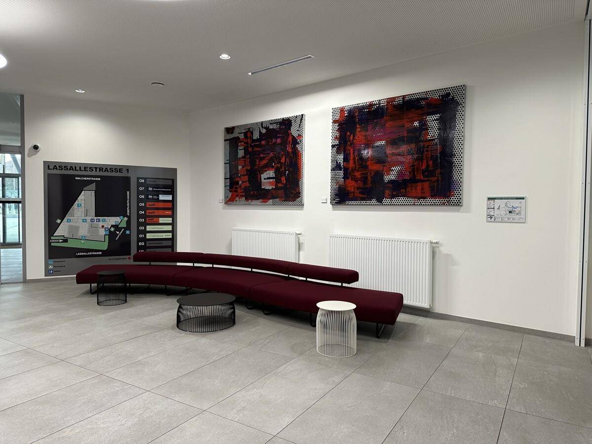 Geräumige und moderne Lobby mit bequemen Sitzgelegenheiten, Kunstwerken und Informationsdisplay.