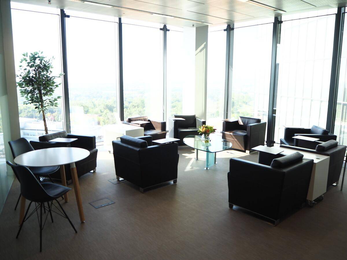 Geräumige Lounge mit bequemen Ledersesseln und großen Fenstern, die eine weite Aussicht bieten.