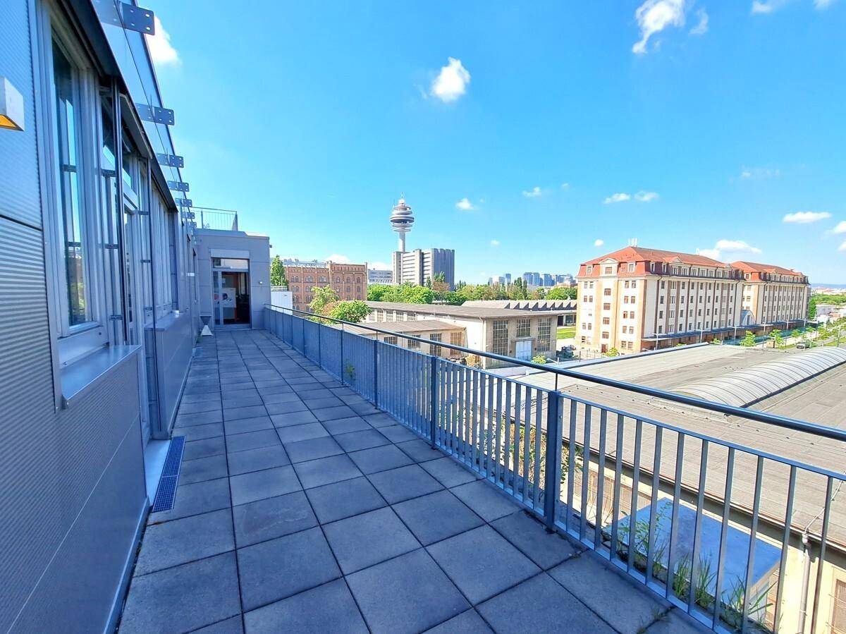 Lange, geflieste Terrasse mit Metallgeländer und Panoramablick über die Stadt und den Fernsehturm.