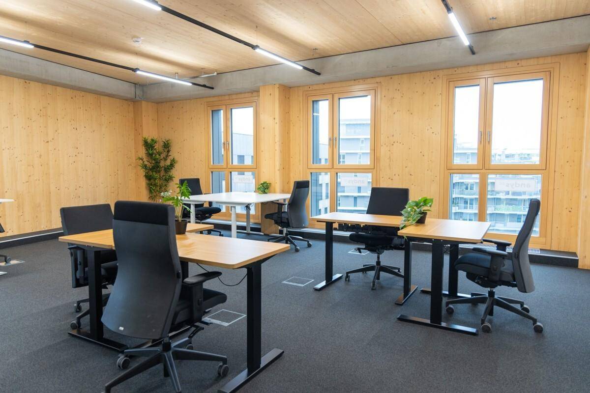 Weitläufiges Büro mit flexiblen Arbeitsplätzen, viel Tageslicht und einer modernen Einrichtung.