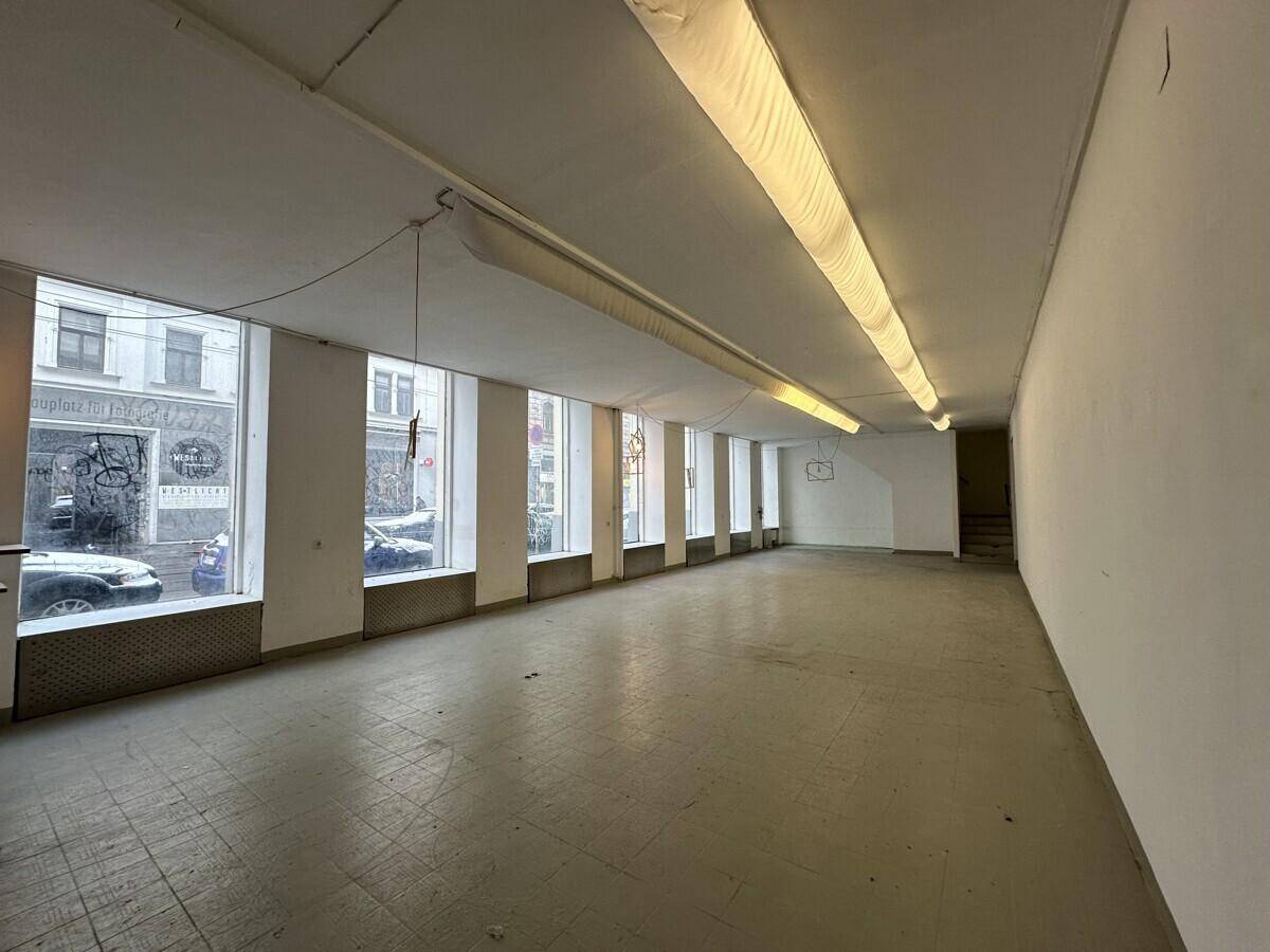 Geräumiger Gewerberaum mit einer Reihe von großen Fenstern, die den Blick auf die belebte Straße freigeben.