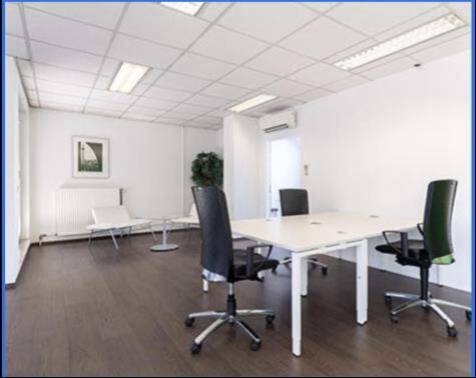 Helles Büro mit dunklem Holzboden, Klimaanlage und einem Schreibtisch mit Bürostühlen für konzentriertes Arbeiten.