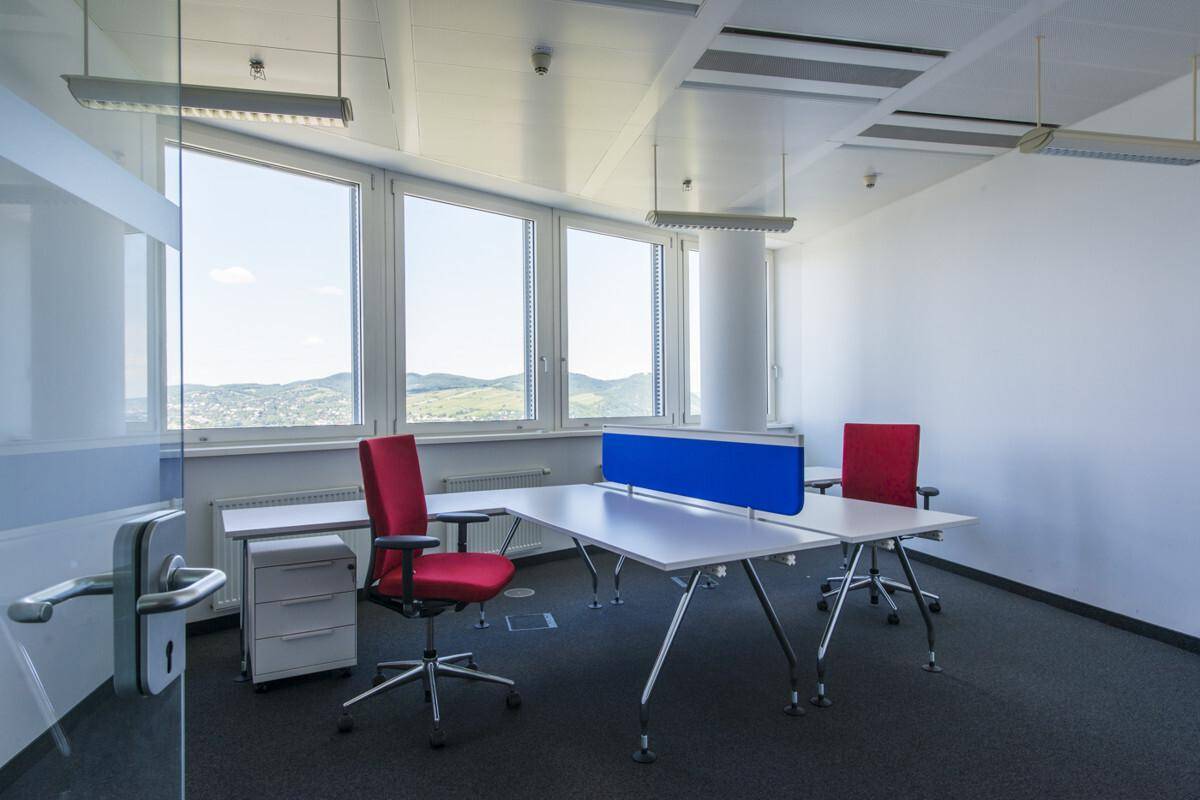 Geräumiges Büro mit großen Fenstern, die einen weiten Blick auf die Landschaft bieten.