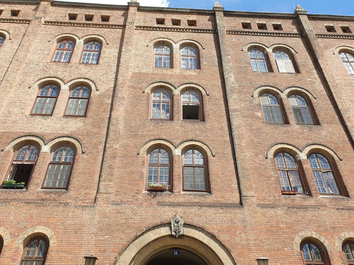 Geräumiger, frisch renovierter Raum mit weiß getünchten Wänden, einer markanten Gewölbedecke und modernem dunklem Bodenbelag.