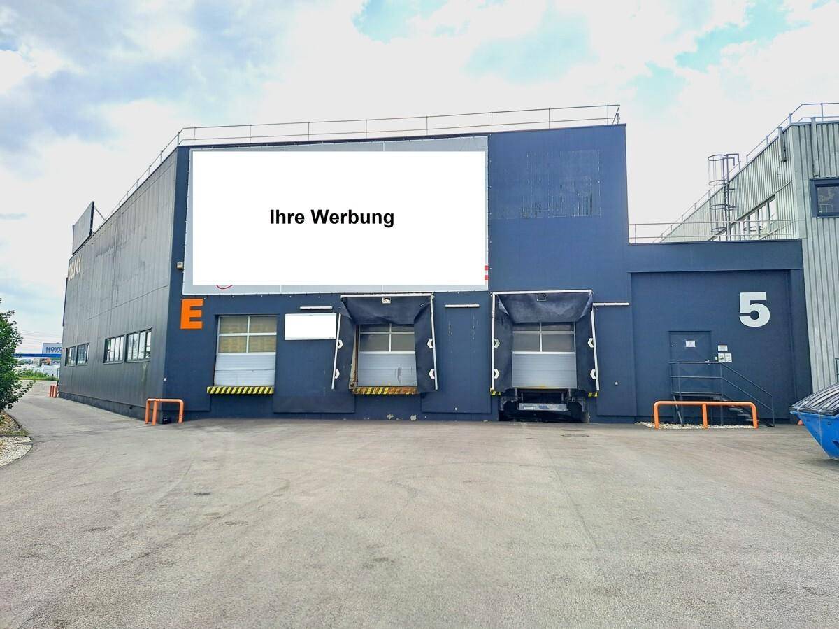 Außenansicht eines Logistikgebäudes mit mehreren Laderampen und einer großen Werbefläche.