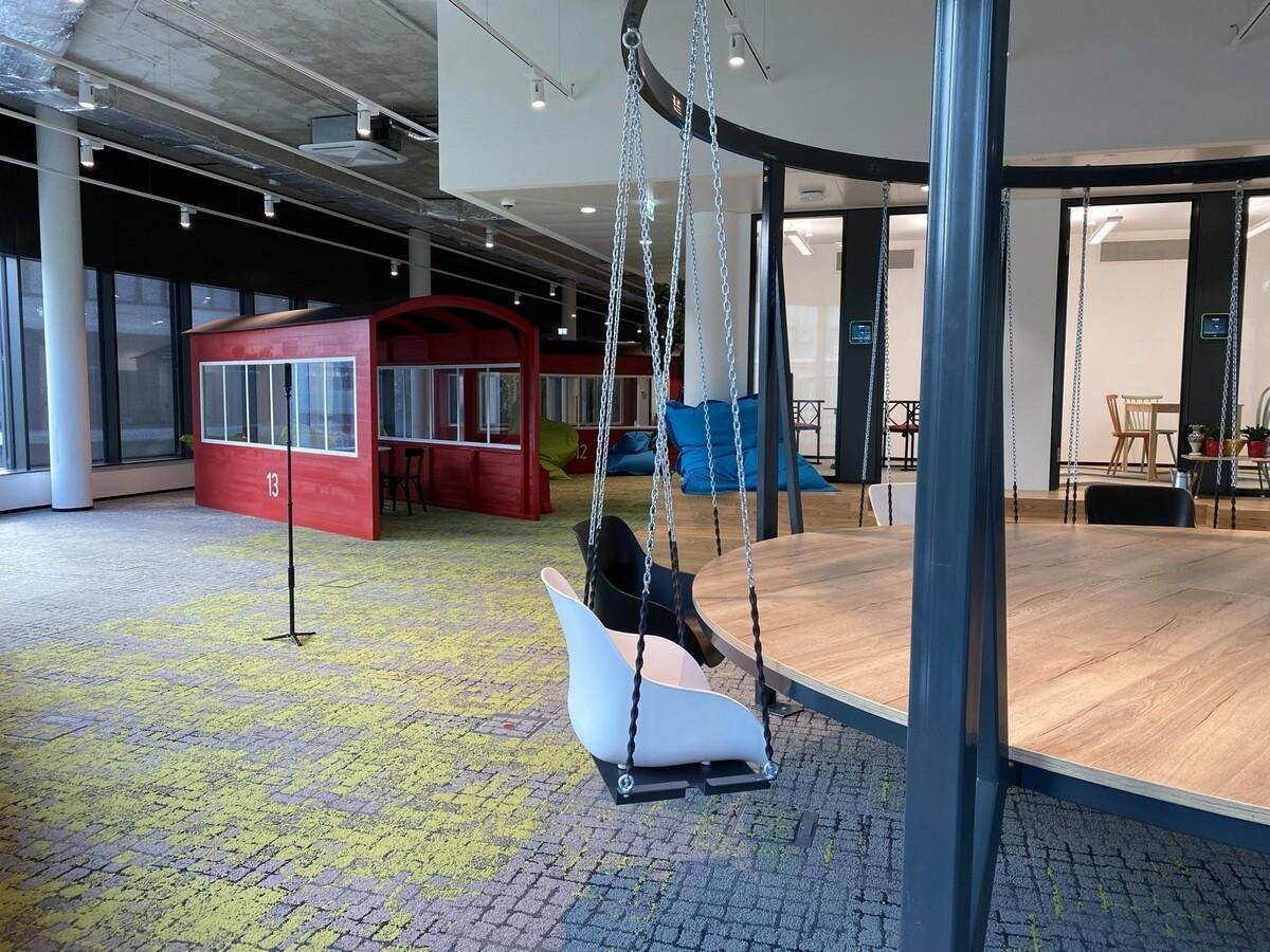 Offener Lounge-Bereich mit bunten Sitzsäcken und kreativen Arbeitsnischen.