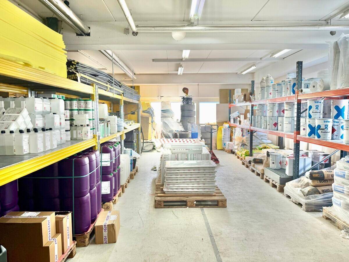 Großes Lager mit hohen Regalen, gefüllt mit verschiedenen Produkten und Materialien, bereit zur Nutzung.