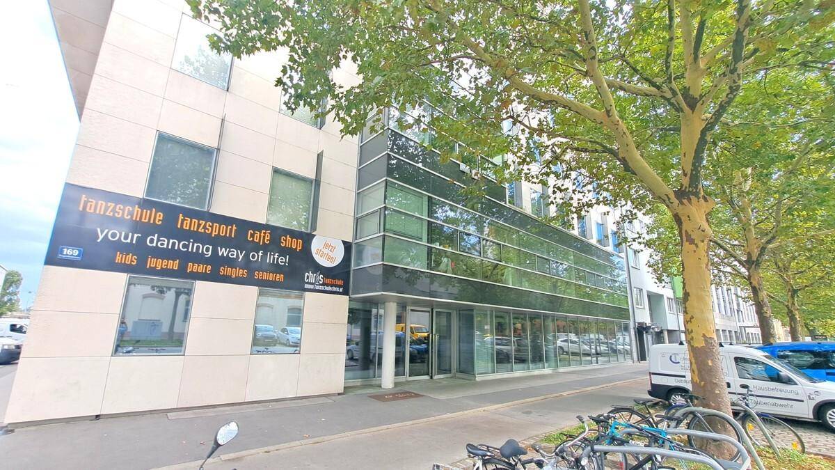 Modernes Geschäftsgebäude mit Glasfassade und einer Tanzschule im Erdgeschoss.