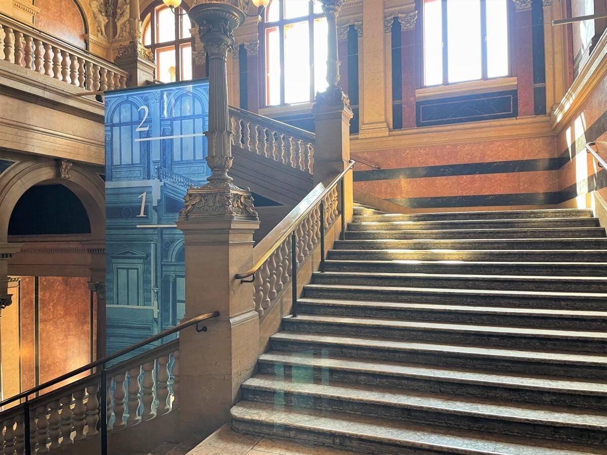 Großzügiges Treppenhaus mit Marmorstufen, kunstvollen Geländern und viel natürlichem Licht.