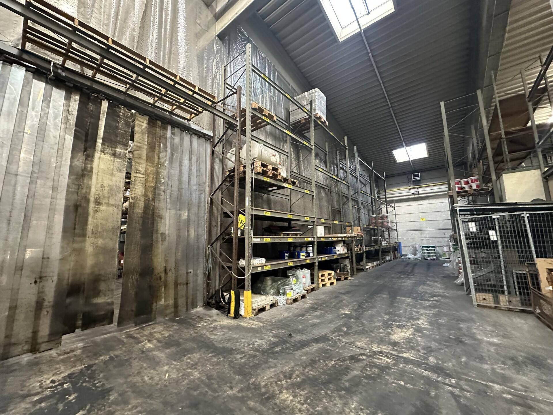 Lagerhalle mit hohen Metallregalen, die mit Baumaterialien gefüllt sind.