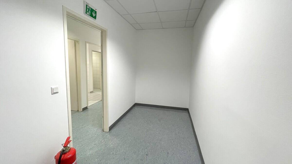 Kleiner, leerer Raum oder Korridor mit Vinylboden und weißen Wänden, sauber und funktional.