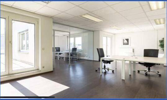 Modernes Büro mit Holzboden, Glaswänden und Zugang zu einem Balkon oder einer Terrasse.