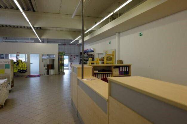 Kassenbereich oder Informationsschalter in einem Baumarkt mit Blick zum Eingangsbereich.