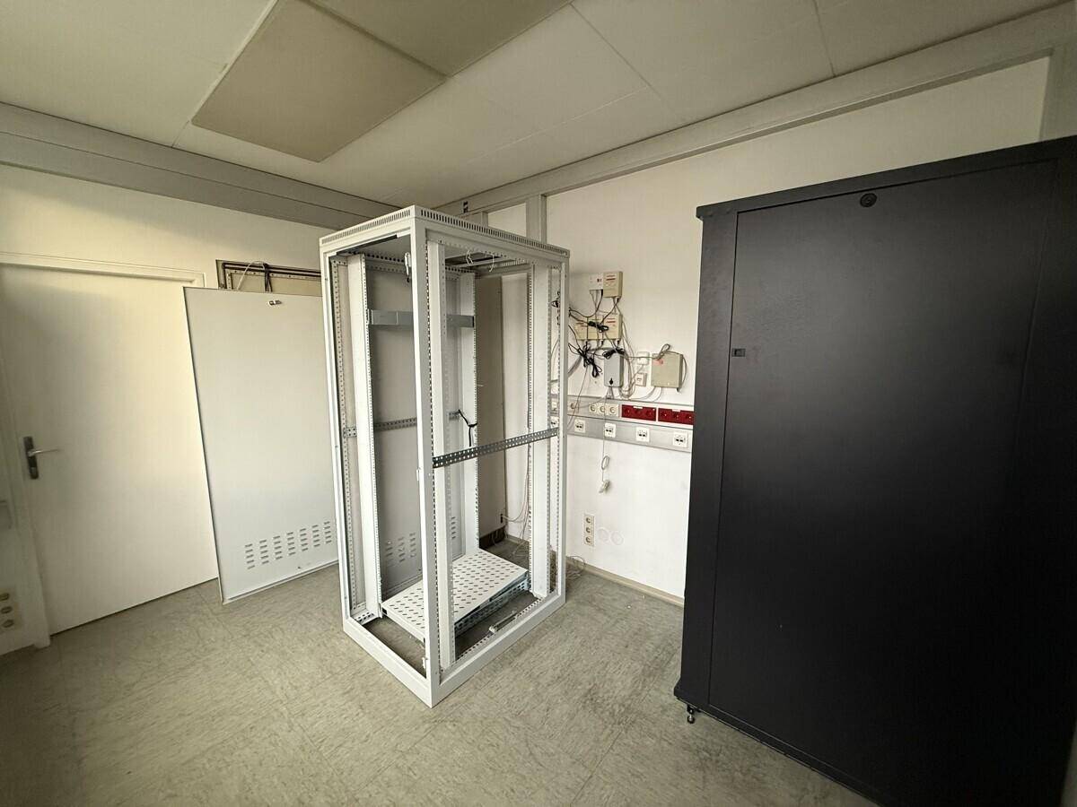 Technischer Raum mit Serverracks und Verkabelung, ausgestattet für IT-Infrastruktur.