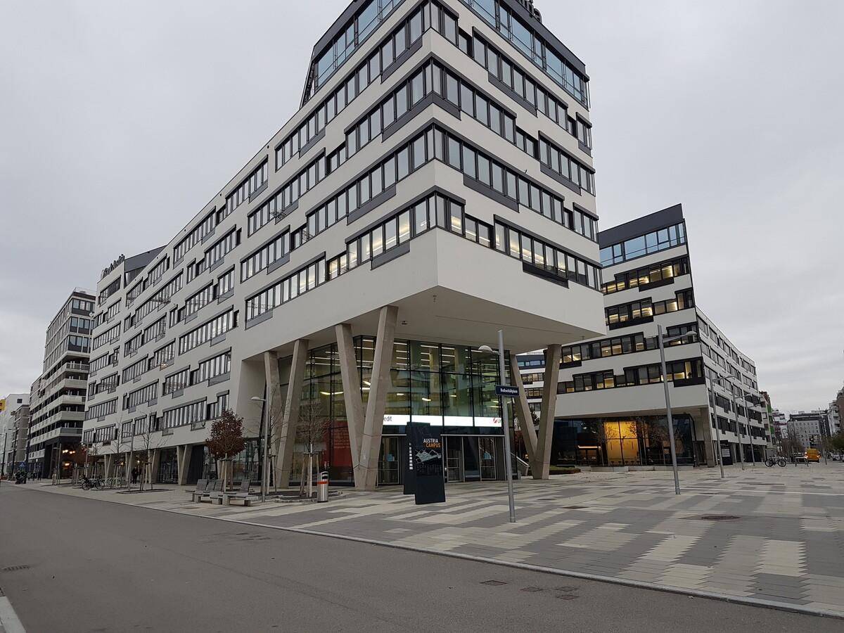 Großes modernes Bürogebäude mit markanter Architektur und Glasfassade an einem bewölkten Tag.