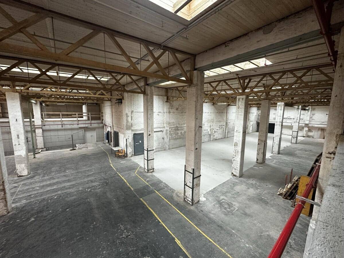 Weitläufige Industriehalle mit Betonpfeilern und sichtbarer Dachkonstruktion, ideal für gewerbliche Nutzung.