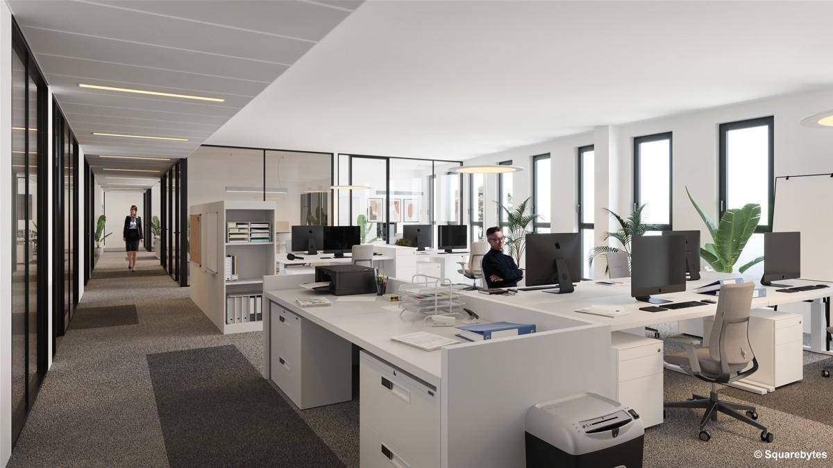 Großraumbüro mit modernen Arbeitsplätzen und viel Tageslicht, durch große Fenster erhellt.