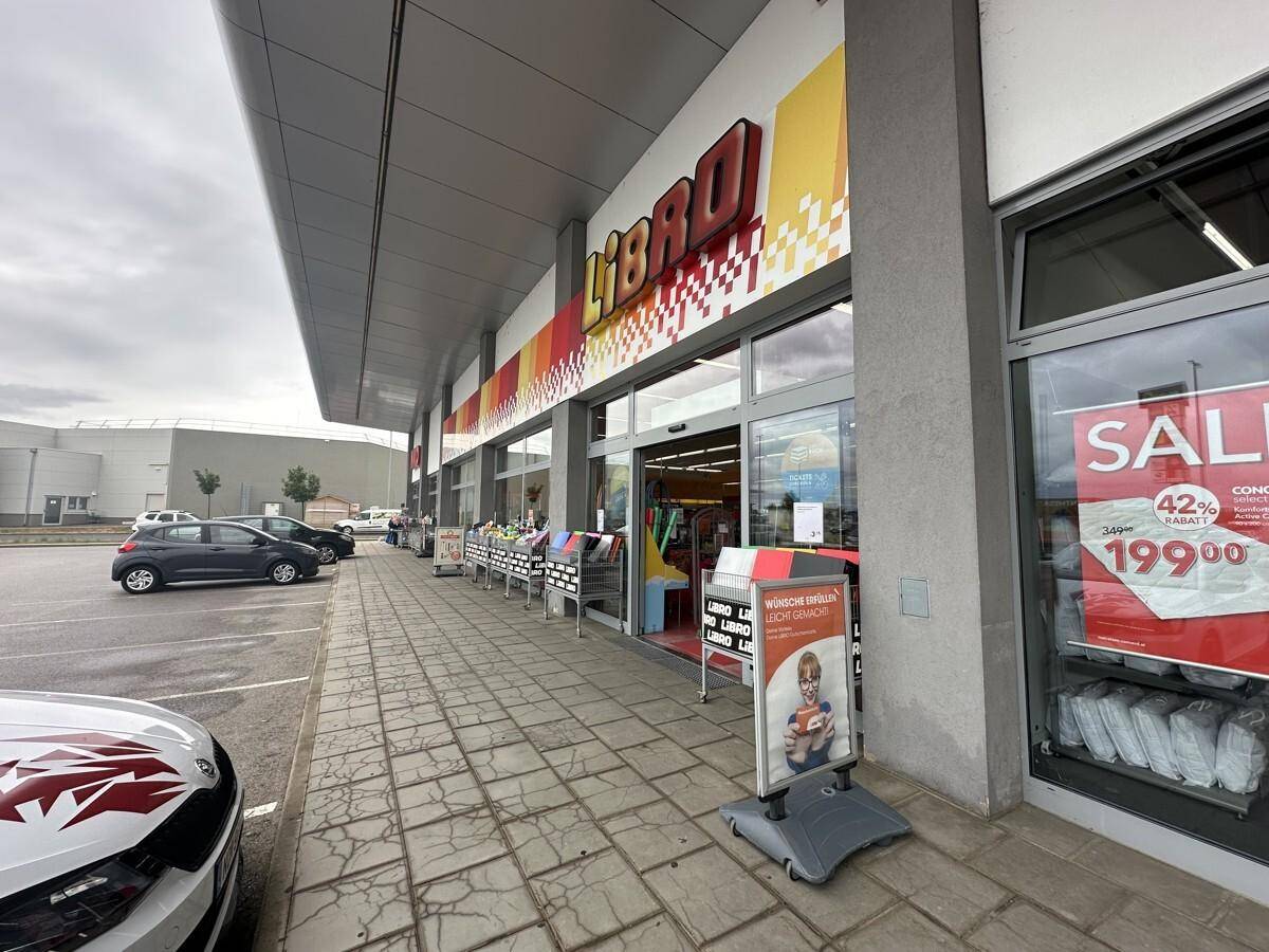 Eingangsbereich des Libro-Geschäfts mit Schaufenstern, Werbeschildern und einem Teil des Parkplatzes.