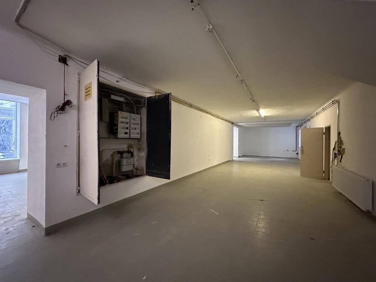 Leerer Gewerberaum mit sichtbarem Stromkasten und einfacher Ausstattung, bereit für den Ausbau.