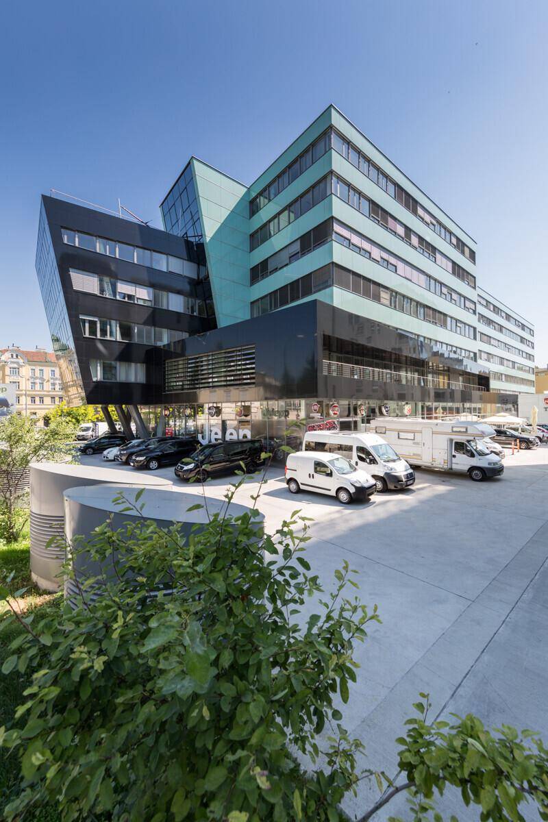 Ansicht des modernen Bürokomplexes mit seiner einzigartigen Architektur und den davorliegenden Parkflächen an einem klaren Tag.