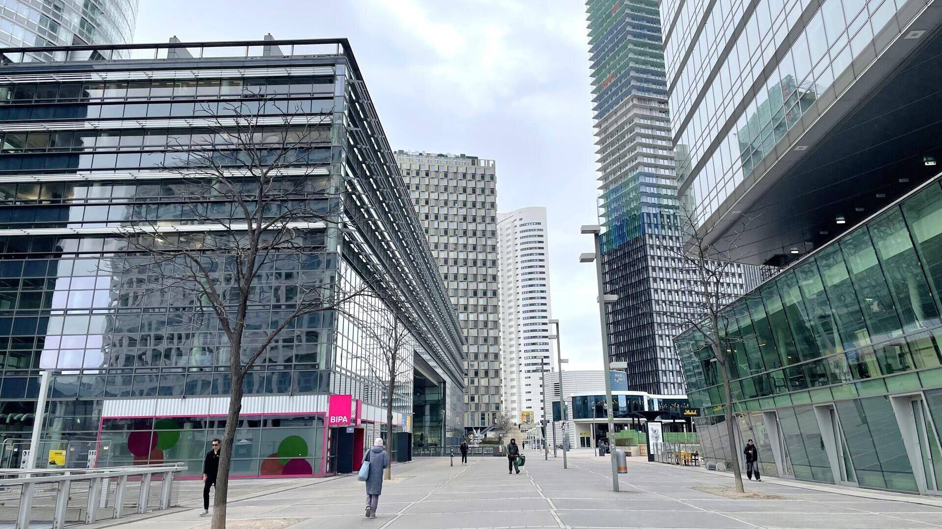 Urbane Szene mit modernen Hochhäusern, Glasfassaden und Fußgängern, die durch die belebte Stadtlandschaft gehen.